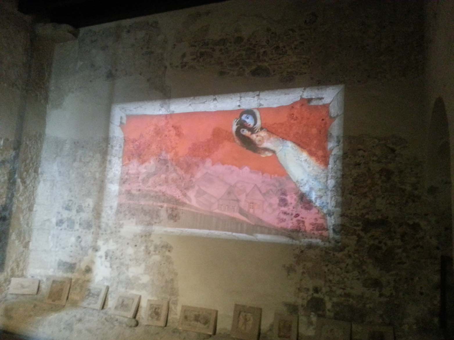 Un quadro animato proiettato su un muro del castello con due amanti che volano