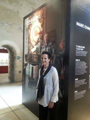 La curatrice della mostra Romit Sorek dietro un pannello che ritrae Chagall